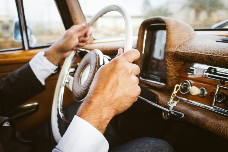 Vintage car with hands on steering wheel | chauffeur driver